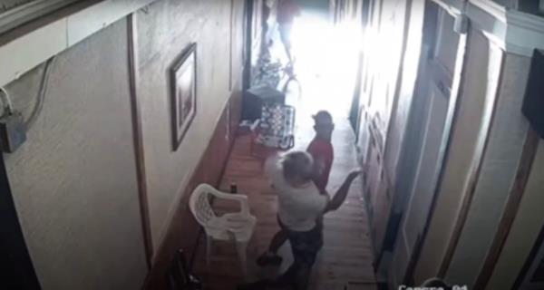 Surveillance footage of a physical altercation in the hallway of the hotel.